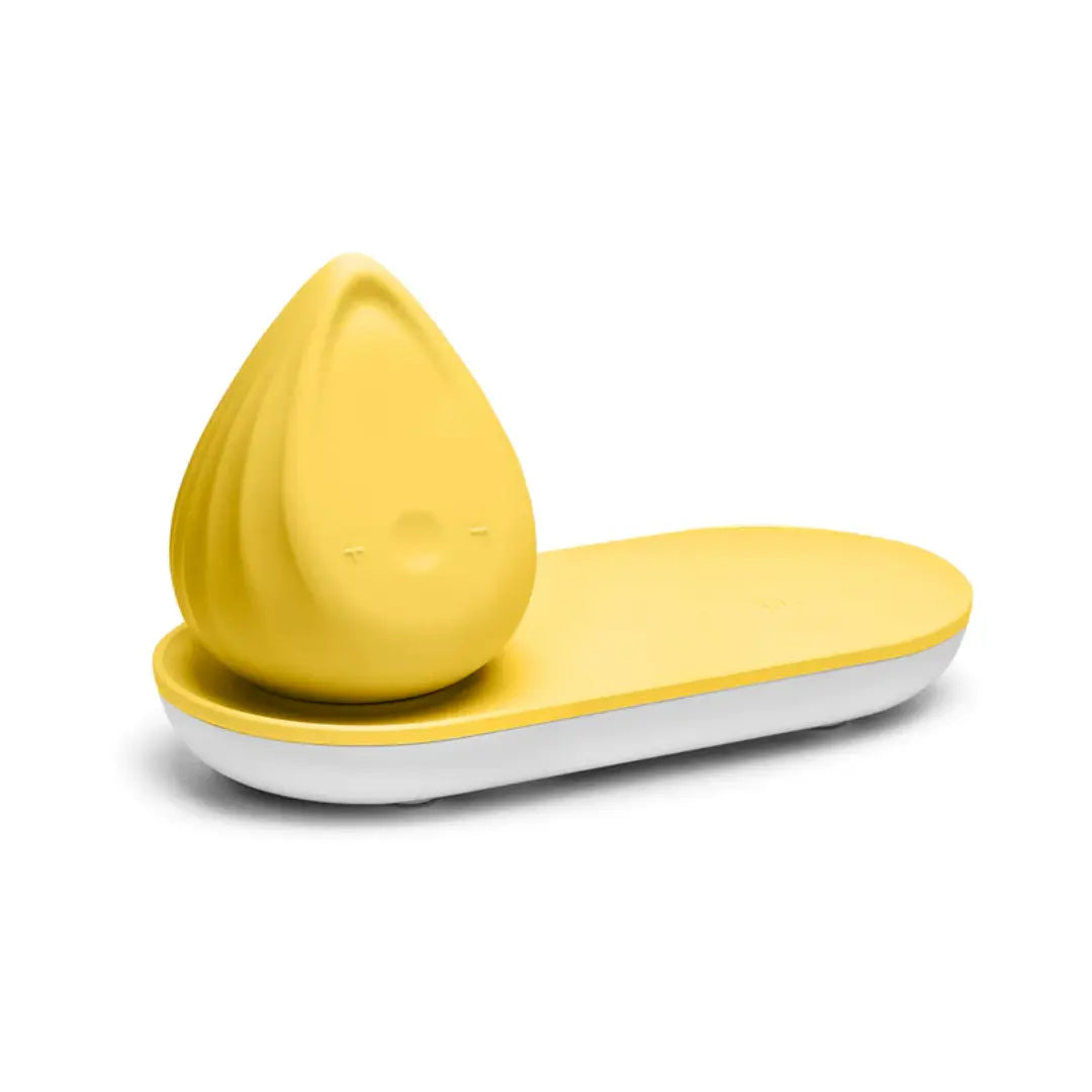 Evii Biird yuzu yellow silicone vibrator resting on coordinating charging tray