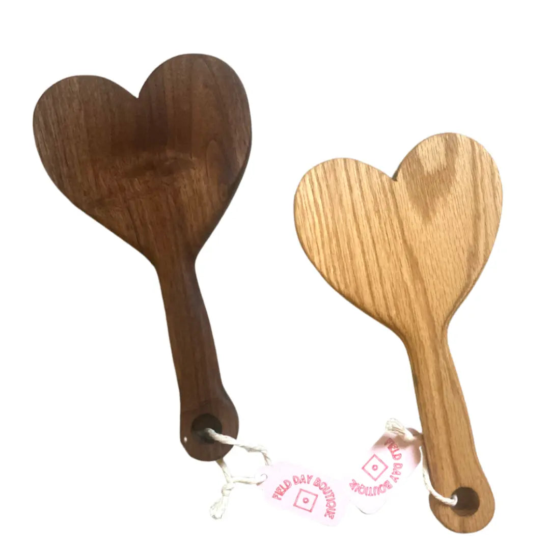 Two handmade Field Day wood paddles in heart shape. One is walnut, a dark wood. The other is ash, a light wood