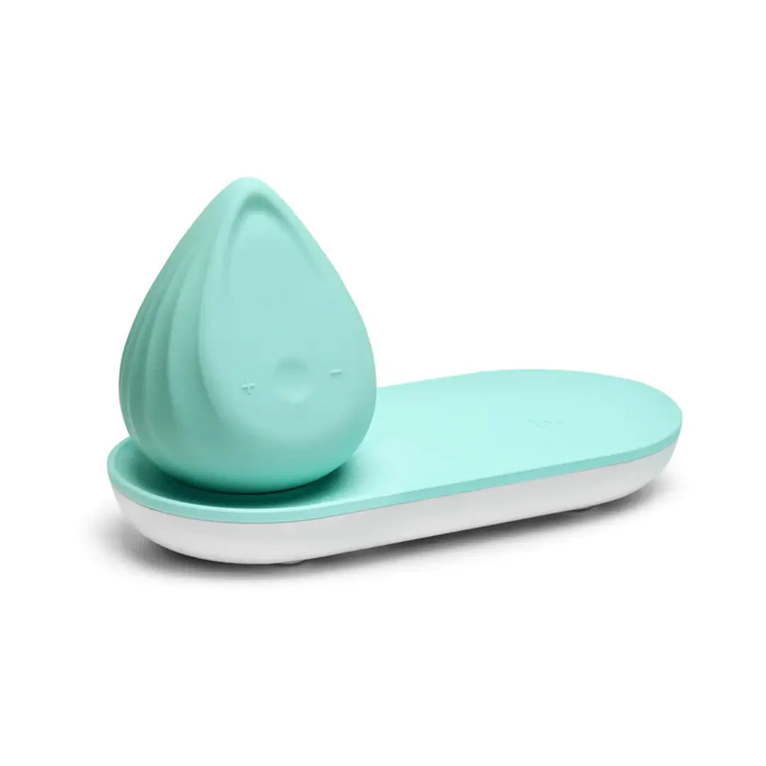 Evii Biird mint green silicone vibrator resting on matching charging tray