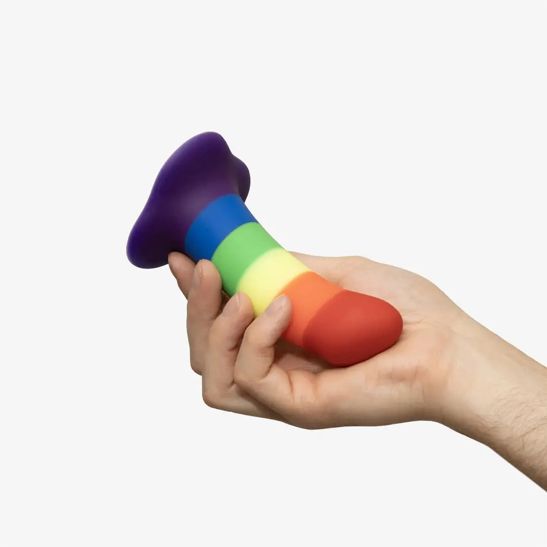 Rainbow striped silicone dildo held in hand